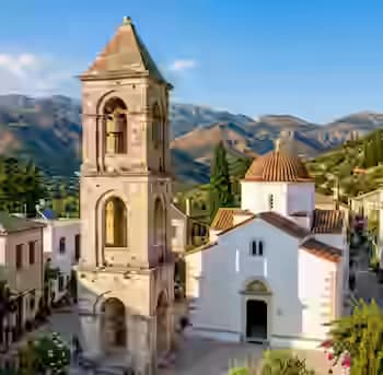 Freistehender venezianischer Steinglockentum neben einer weißen byzantinischen Kirche in einem Bergdorf auf Zakynthos, Ionische Inseln, Griechenland